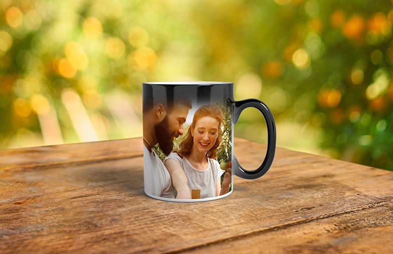 Magic Mug|Three mugs, being filled with hot water to reveal a baby.|Young boy holding custom designed magic mug with photo of himself on|Magic mug with picture of cat on having tea poured into it on desk|Couple holding two heat changing magic mugs with custom text by Printerpix|Three mugs: one empty (blank), one half full (half an image) and one full (full image)|Grandad and grand daughter holding hands with personalised mug with photo of grand daughter||||